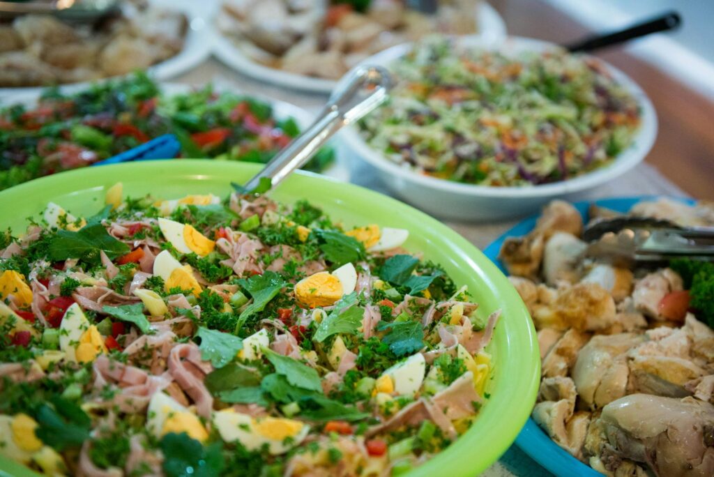 From above homemade appetizing salads and dishes served in bowls on table during family gathering party