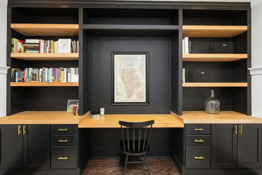 A home office with black cabinets and a desk