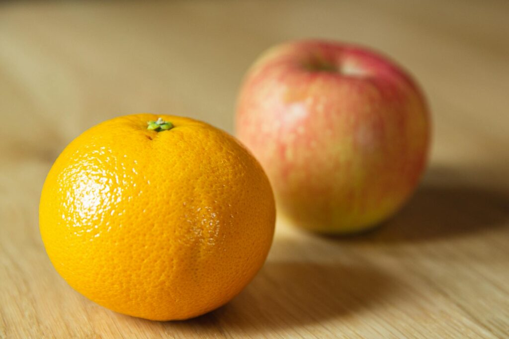 Ripe fresh tangerine with apple on table