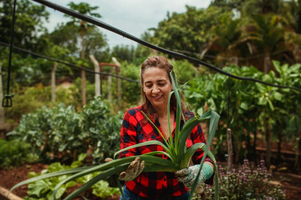 A woman in a garden holding a plant