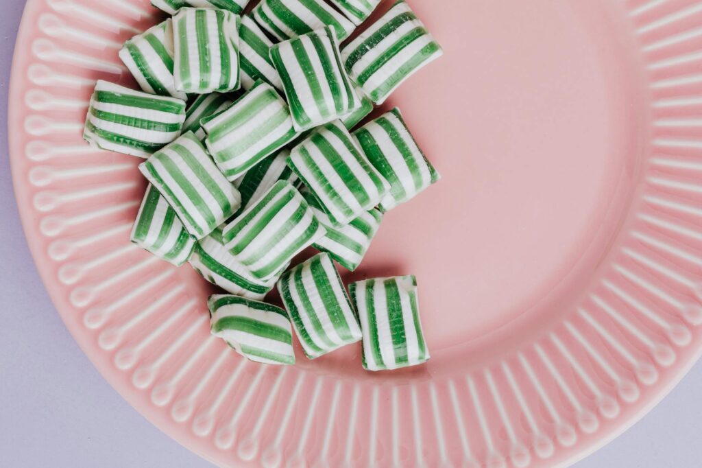 Set of delicious candies on pink plate