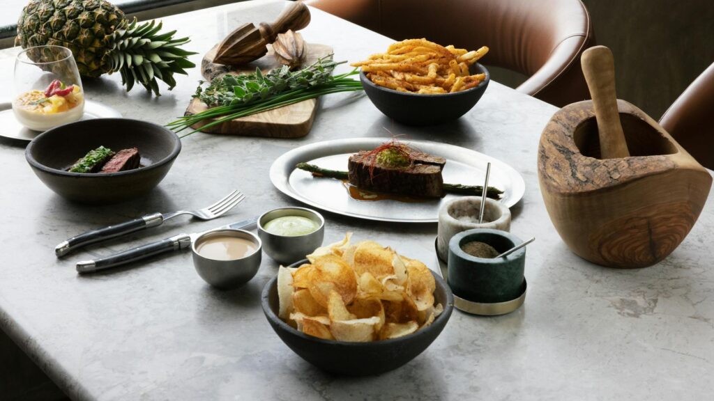 A table with bowls of food and a pineapple