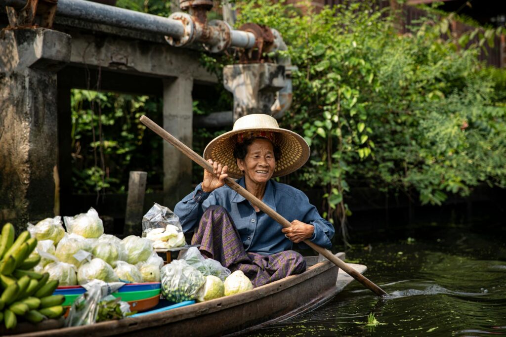 A woman in a boat with vegetables and fruit