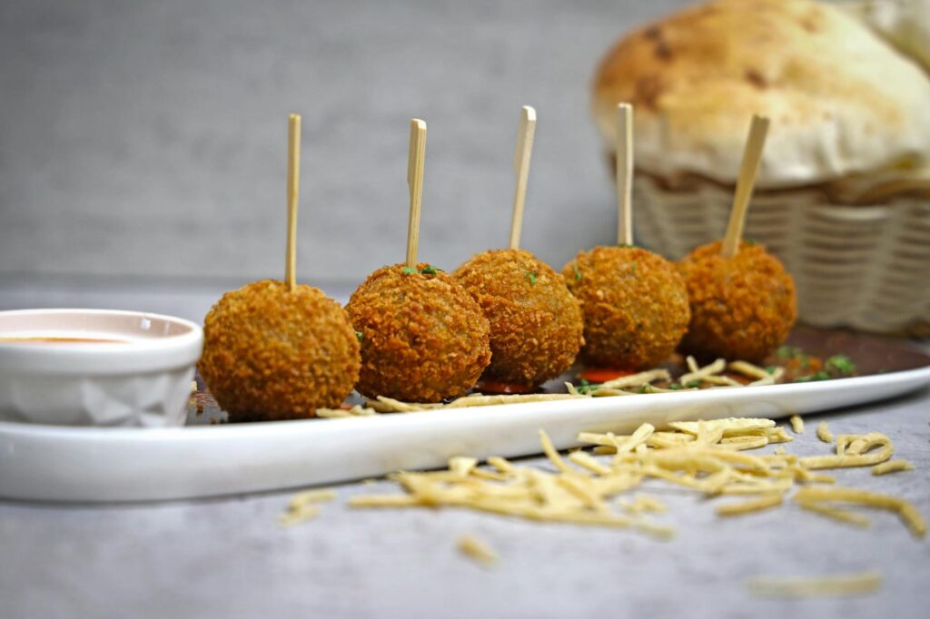 A plate with meatballs and bread sticks on it